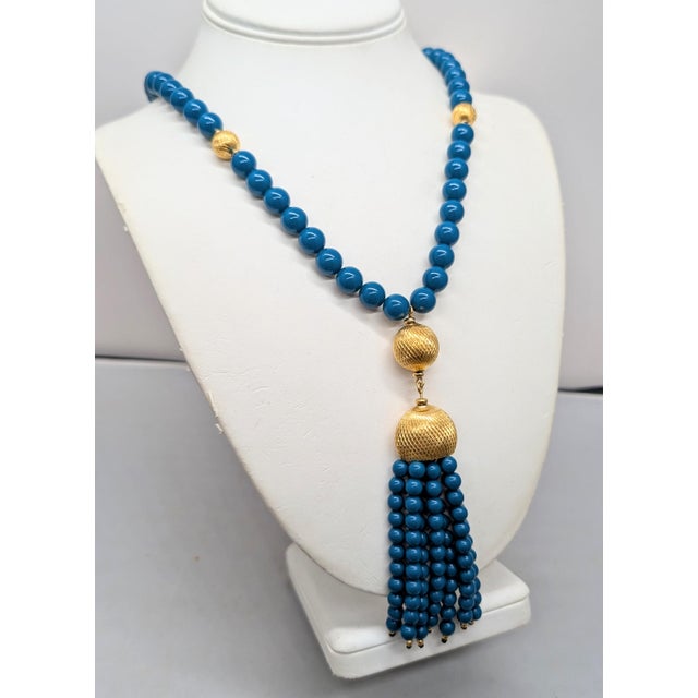 1980s goldtone beaded faux-lapis necklace with faux-lapis beaded tassel pendant with goldtone textured top with spherical...