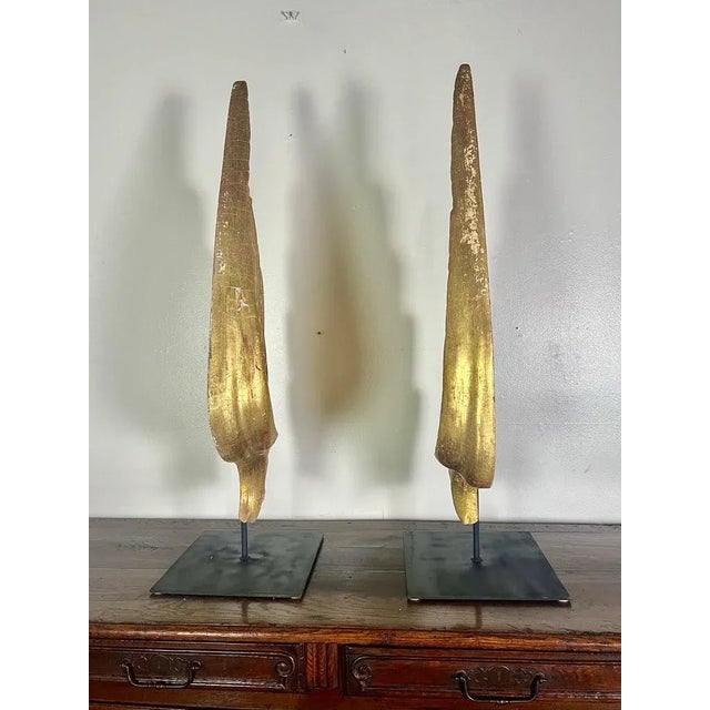 Pair of 19th century Italian Baroque style 22K giltwood wings. The wings have been mounted on iron bases. Wear is...