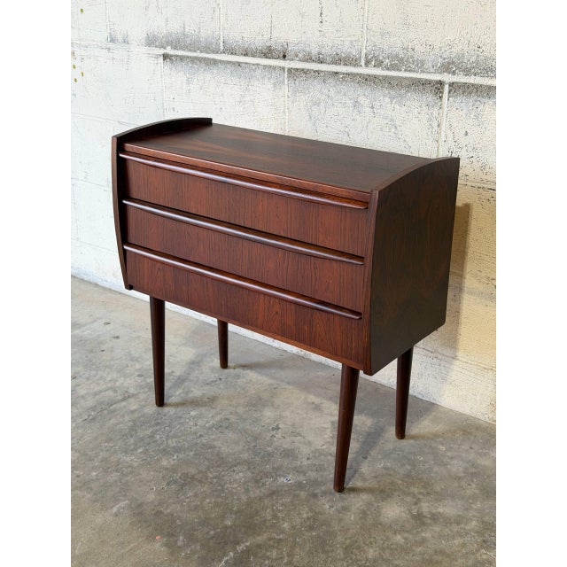 This compact chest features a clean rectangular silhouette elevated on elegantly tapered legs. The front is fitted with...