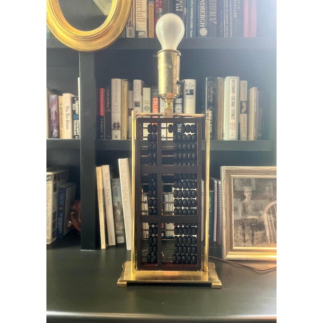 Early midcentury lamp featuring a Chinese wooden abacus and brass frame. Newly rewired and new black oval shade with gold...