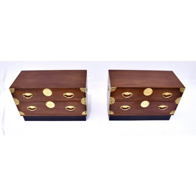A pair of Henredon Chinoiserie Tansu Commode size nightstands with traditional Campaign styling. Constructed of Mahogany...