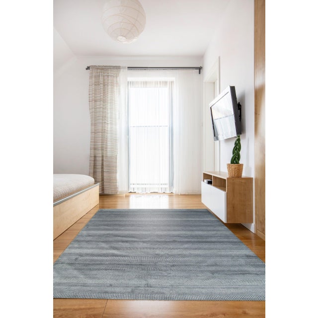 Graceful Blue Hand Knotted Wool & Viscose Rug, Country of Origin: India. This exceptional piece showcases the refined...