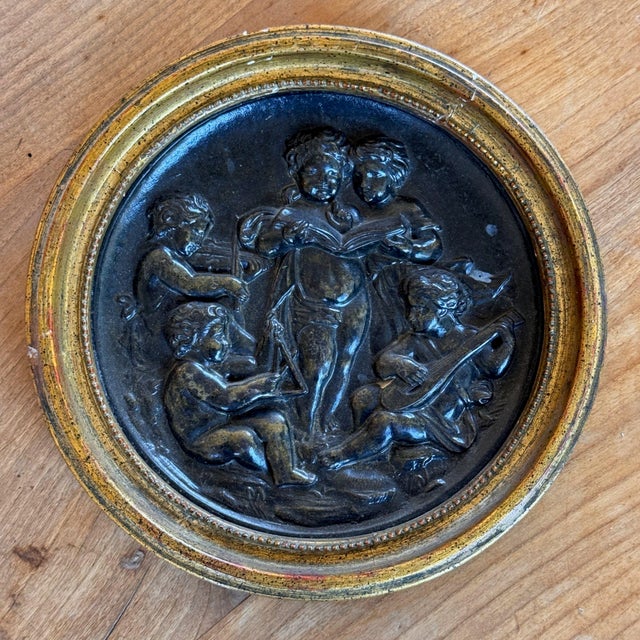 19th century Italian dark relief roundel of five putti gathered for a concert. Two stand at the center singing from an...