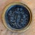 19th century Italian dark relief roundel of five putti gathered for a concert. Two stand at the center singing from an...