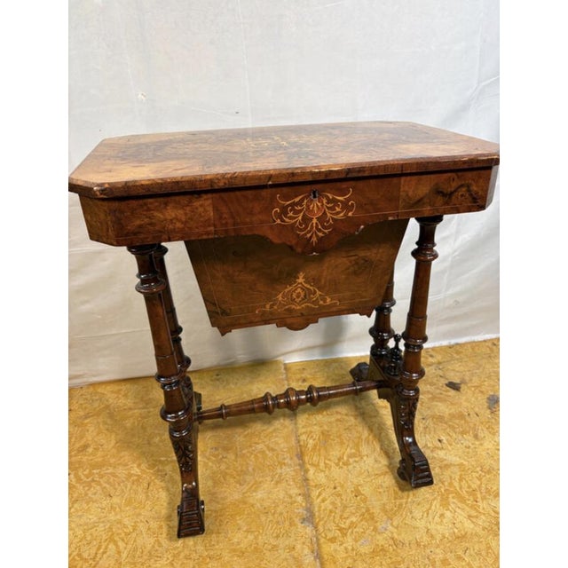 Rich with the charm of a bygone age, this exquisite Victorian burr walnut sewing table is a graceful reminder of the...