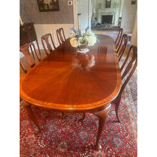 A Queen Anne Style oval Dining Table by high quality furniture maker Hickory Chair. Mahogany with banded edge and sunburst...
