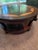 Professionally refinished elegant French-inspired round coffee table features striking two-tone wood with a starburst...