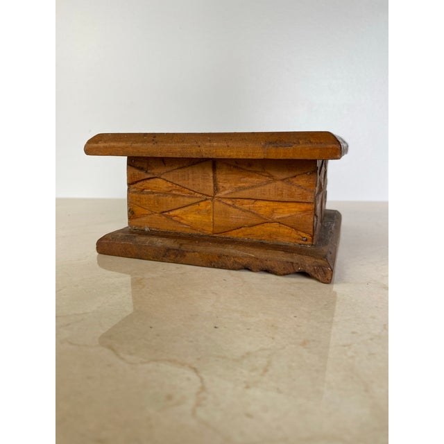 A charming hand-carved wooden folk art box featuring a carved star medallion set within a geometric bordered lid, and bold...