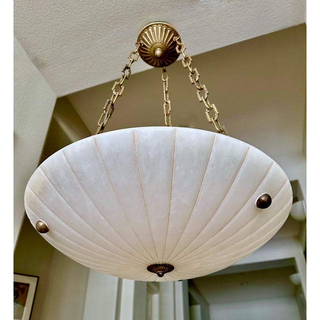 French alabaster pendant light with brass aged (antiqued) finish fittings in the Directoire style. Interior lighting uses...