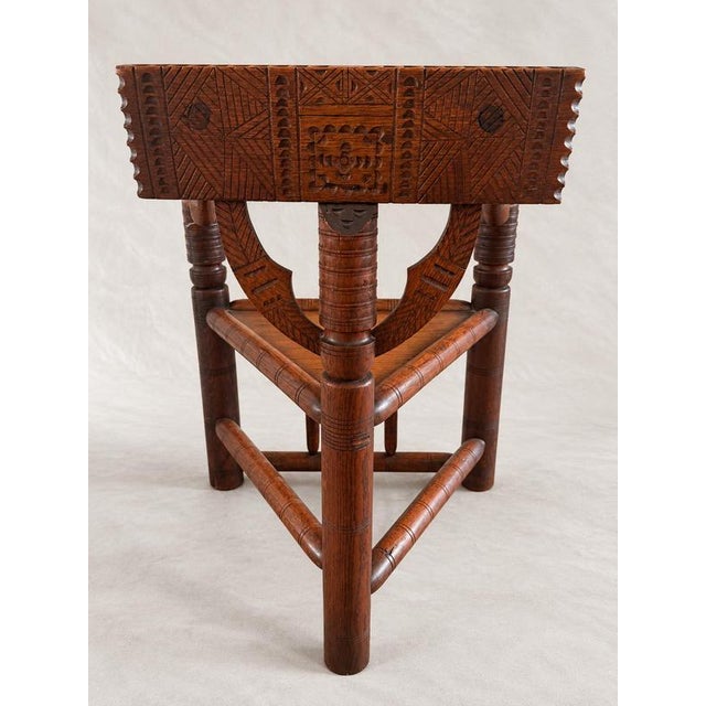 An imposing antique triangular corner chair in stained and polished solid hardwood, predominantly oak, with a richly...