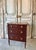 A small louis xvi style mahogany commode, dating from the mid-20th century. The front features three drawers, each with a...