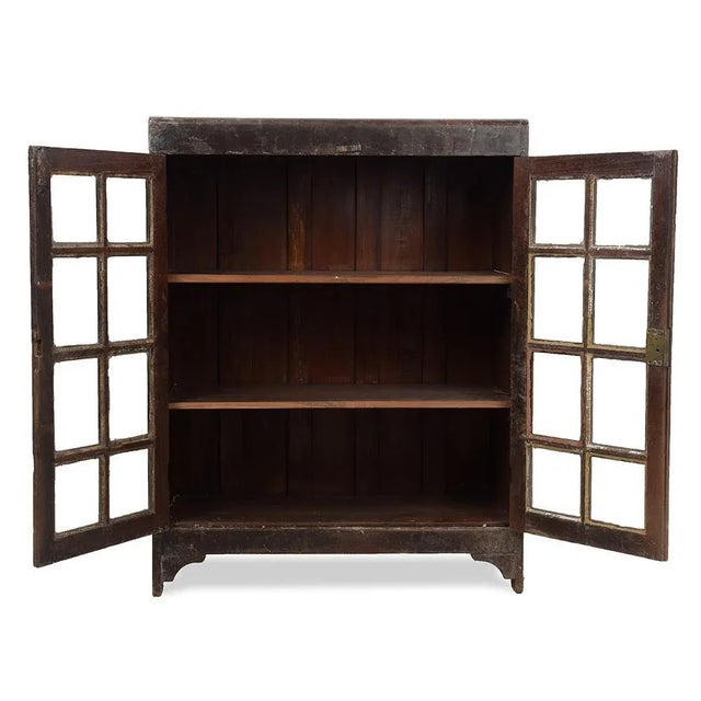 This glass wardrobe with dark wood and classic silhouette measures 91 cm high and 72 cm wide, offering an elegant presence...