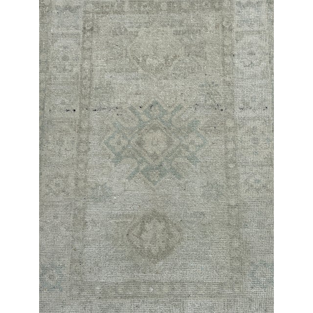 Stone-washed Khotan rug, hand-knotted in Afghanistan from 100% wool. Measuring 1’11” x 3’, the rug features a softly faded...