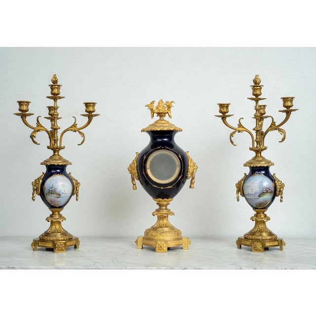 Antique French Napoleon III clock triptych in expertly chiseled gilded bronze and polychrome Sevres porcelain. The clock...