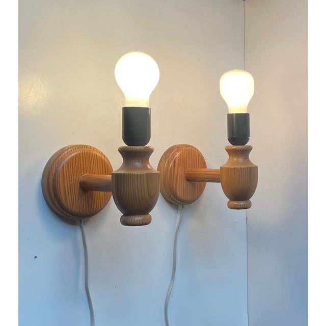 A set of 2 wall lamps fashioned from engine turned oregon pine. Designed and made in-house by plus lys in denmark circa...
