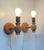 A set of 2 wall lamps fashioned from engine turned oregon pine. Designed and made in-house by plus lys in denmark circa...