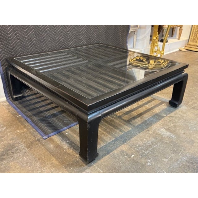 The Mid-Century Modern Black Lacquer and Glass Table is a stylish and elegant piece of furniture with a Chinese design....