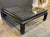 The Mid-Century Modern Black Lacquer and Glass Table is a stylish and elegant piece of furniture with a Chinese design....