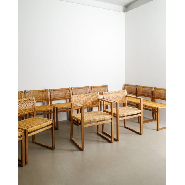 A very rare set of fourteen danish mid century wooden dining chairs in stained oak and woven cane seats and backs. This...