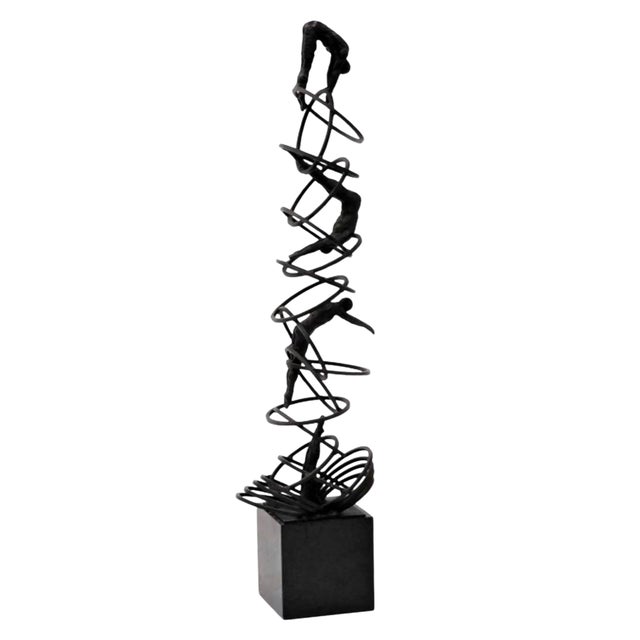A dramatic 20th‑century bronze modernist kinetic sculpture featuring three acrobats in ascending gymnastic poses along a...