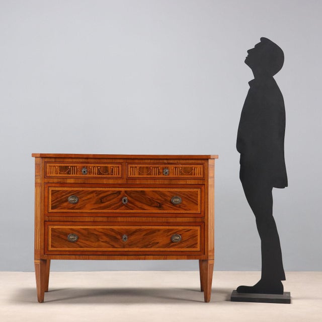 Neoclassical chest of drawers in walnut and walnut burl, with various wood trim and inlays. The front has four drawers,...