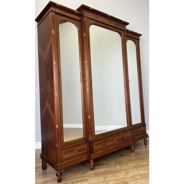 This elegant Antique French wardrobe is a striking piece featuring beautiful French inlay decoration, mirrored doors, and...
