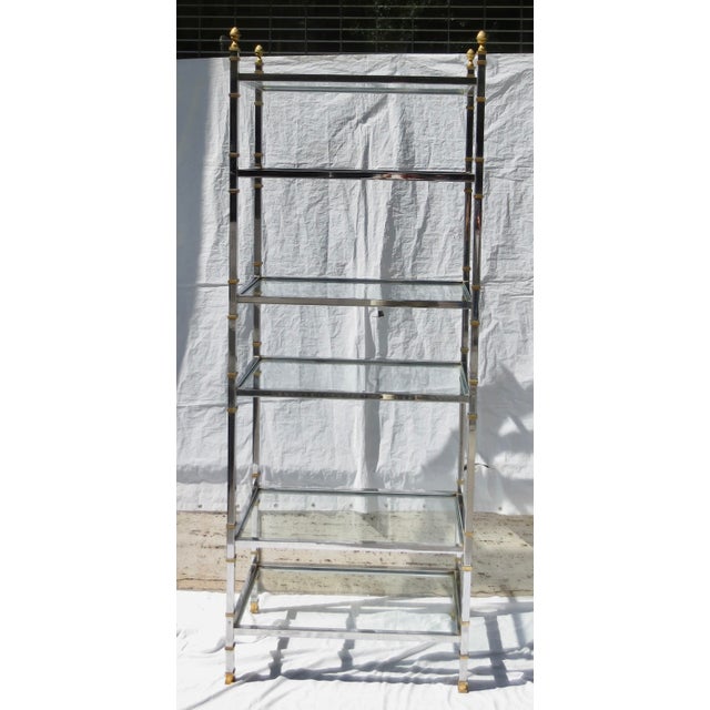 Vintage 70s etagere with chrome frame and brass feet, finials, and banded shelf points. A mid-century chrome shelving...