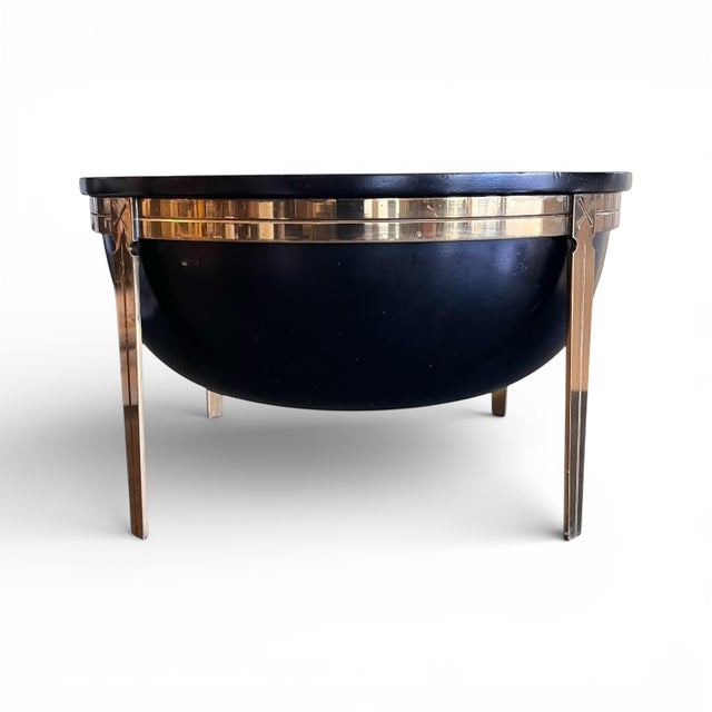 A stylish late 20th century decorative bowl of ebonized and turned wood on four brass legs with neoclassical inspired motifs.
