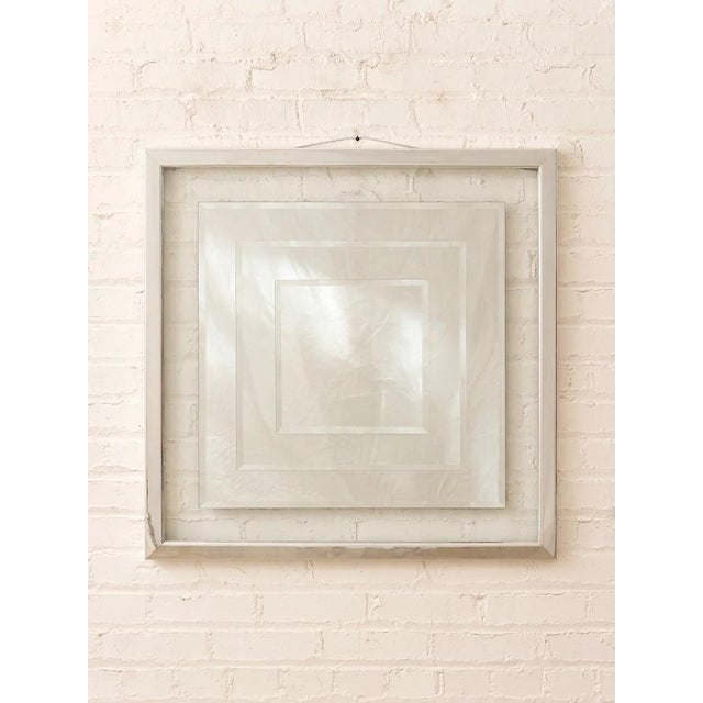 A striking vintage wall mirror with a bold layered geometric design and polished chrome-tone framing. Multiple beveled...