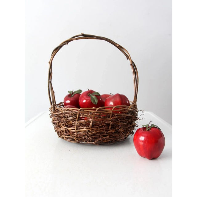 This is a rustic vintage twig basket. The gathering basket has a wild woven wicker body with loosely braided willow handle.