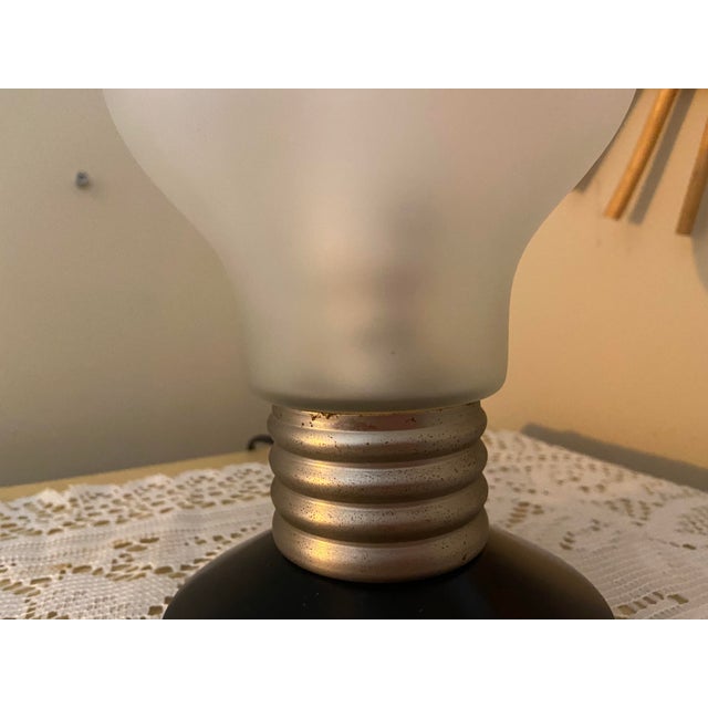 A playful and collectible vintage IKEA BLINDA table lamp from the 1990s, featuring an oversized light bulb design. This...
