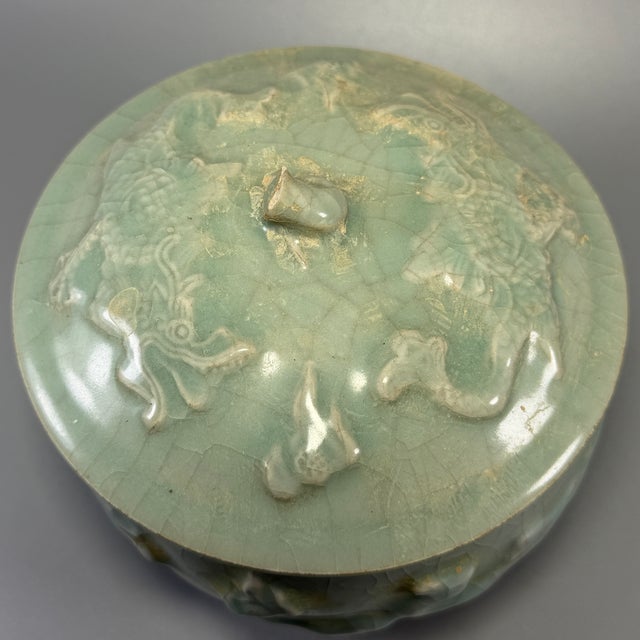 Fine antique Chinese celadon covered jar. Bulbous body adorned with raised relief motifs, matching decorated lid, natural...