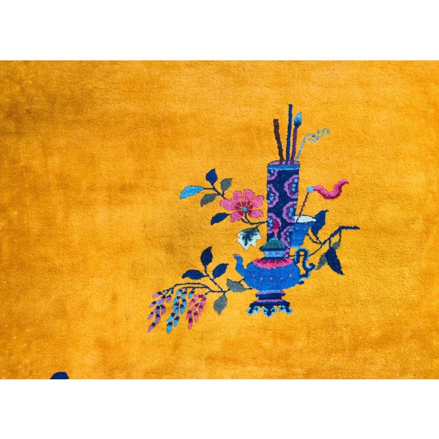A wonderful and brilliant early 20th century Chinese Art Deco rug with a brilliant gold central field surrounded by a wide...