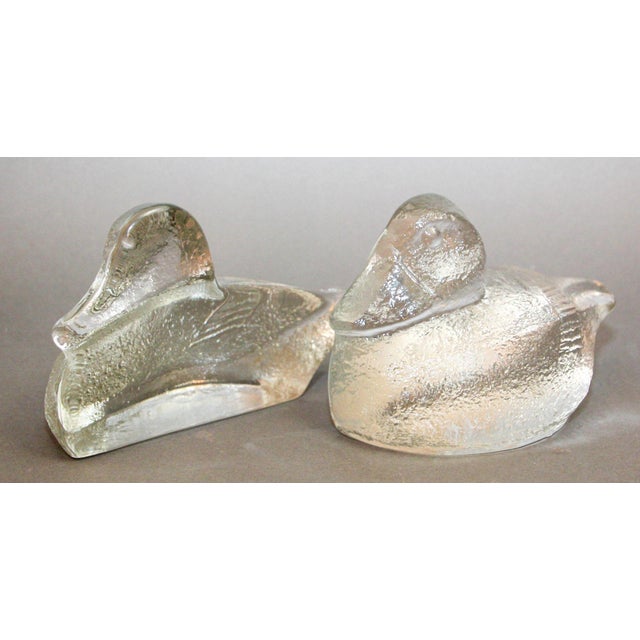 Striking pair of duck glass bookends by Blenko, circa 1980s. Pair of Blenko Ducks bookends featured in a clear textured...