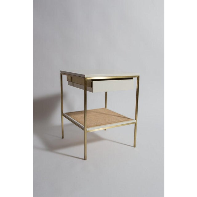 re: 392 lacquer and brass bedside tables with natural caned shelves. These tables have been in production for 15 years and...