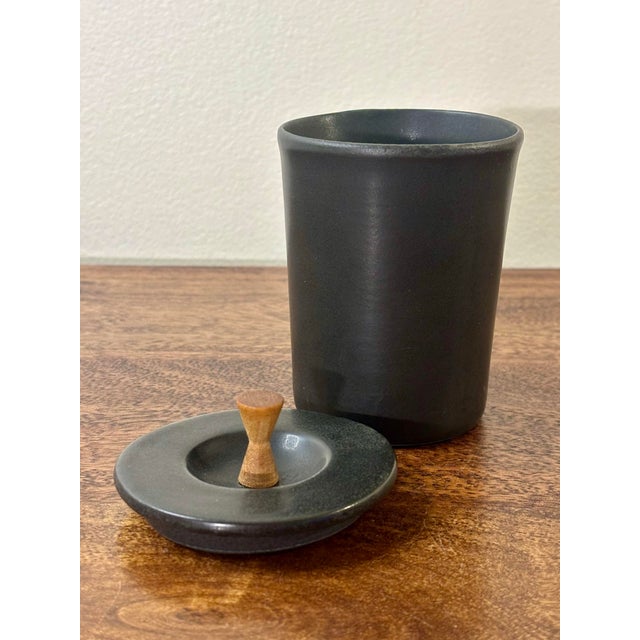A sculptural Mid-Century Modern studio ceramic jar finished in a rich slate black glaze with an organically textured...