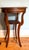 A vintage round two-tier mahogany side table with a wide banded border of lighter, straight-grained mahogany veneer with a...