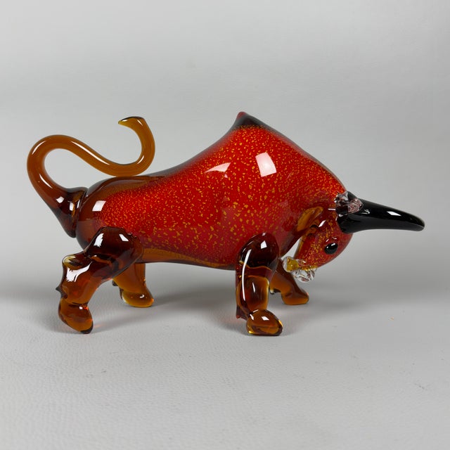 A magnificent animal sculpture in Murano glass, dating back to the 1970s. The work depicts a bull in a charging stance, an...