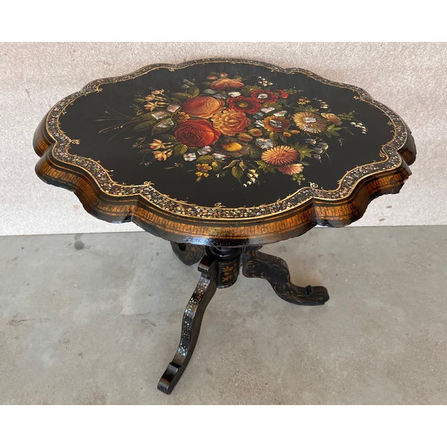An antique English lacquer Papier Mâché tilt top occasional table, hand painted with floral motifs and inlaid with mother-...