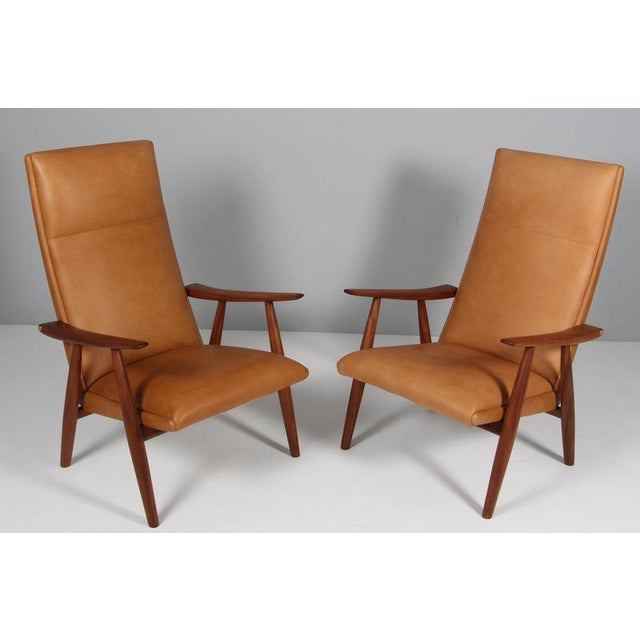 Hans J. Wegner model GE-260 pair of lounge chairs new upholstered with cognac vintage full grain aniline leather. Frame of...
