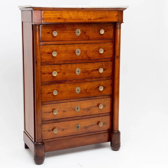 High chest or semainiere with seven drawers, marble top, brass handles and columns.