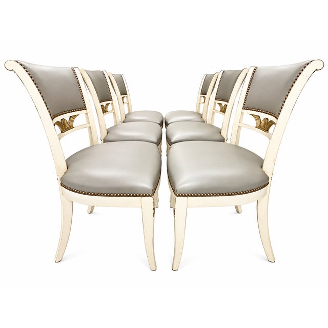 Set of six circa-1930s dining chairs featuring gracefully curved wood frames with a painted cream and gold finish,...