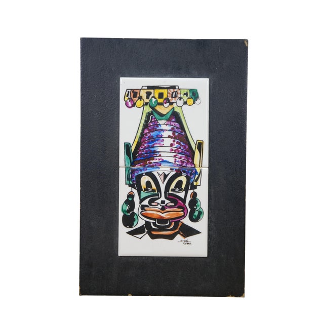 Pair of vintage 20th century works of art on porcelain tiles. Shows a pair of brightly colored faces / masks with...