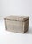This vintage white painted wicker storage basket features a hinged lid and woven side handles, crafted in a classic...