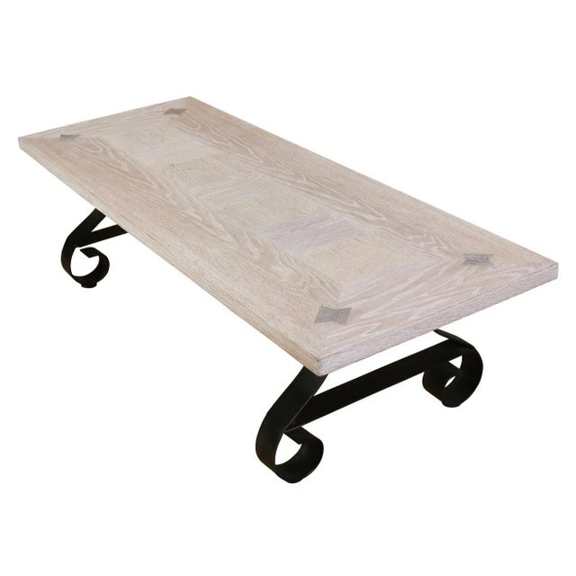 A vintage coffee table of cerused oak with scroll iron base. Table top has an interesting geometric design with a border