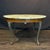 Elegant French coffee table with a beautifully veined marble top resting above a richly toned frieze, centered by a...