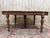 Solid wood oval dining table, composed of two interlocking half-tabletops, resting on six turned baluster legs...