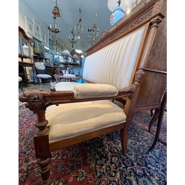 Stunning French hall bench with carvings of lion heads. Crafted of walnut, turn-of-the-century. 68w x 26"d x 50"h