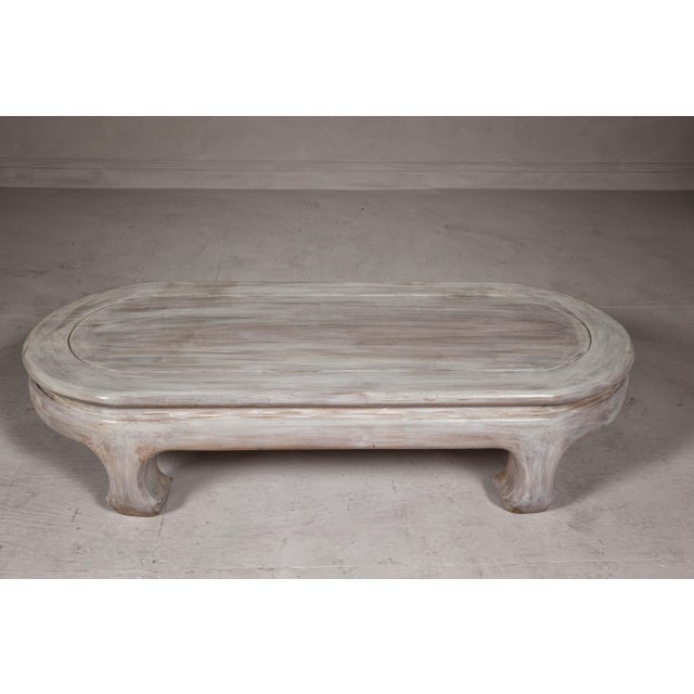 A teak wood vintage whitewash low coffee table with oval top and simply carved legs. Born from vintage charm, this...