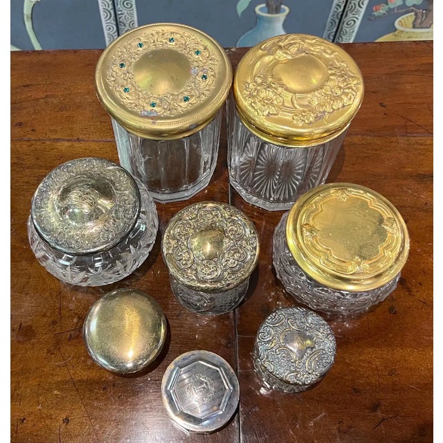 Set of 8 cut glass jars- some with pressed brass lids, some with silver lids. A few of the silver ones are marked with...
